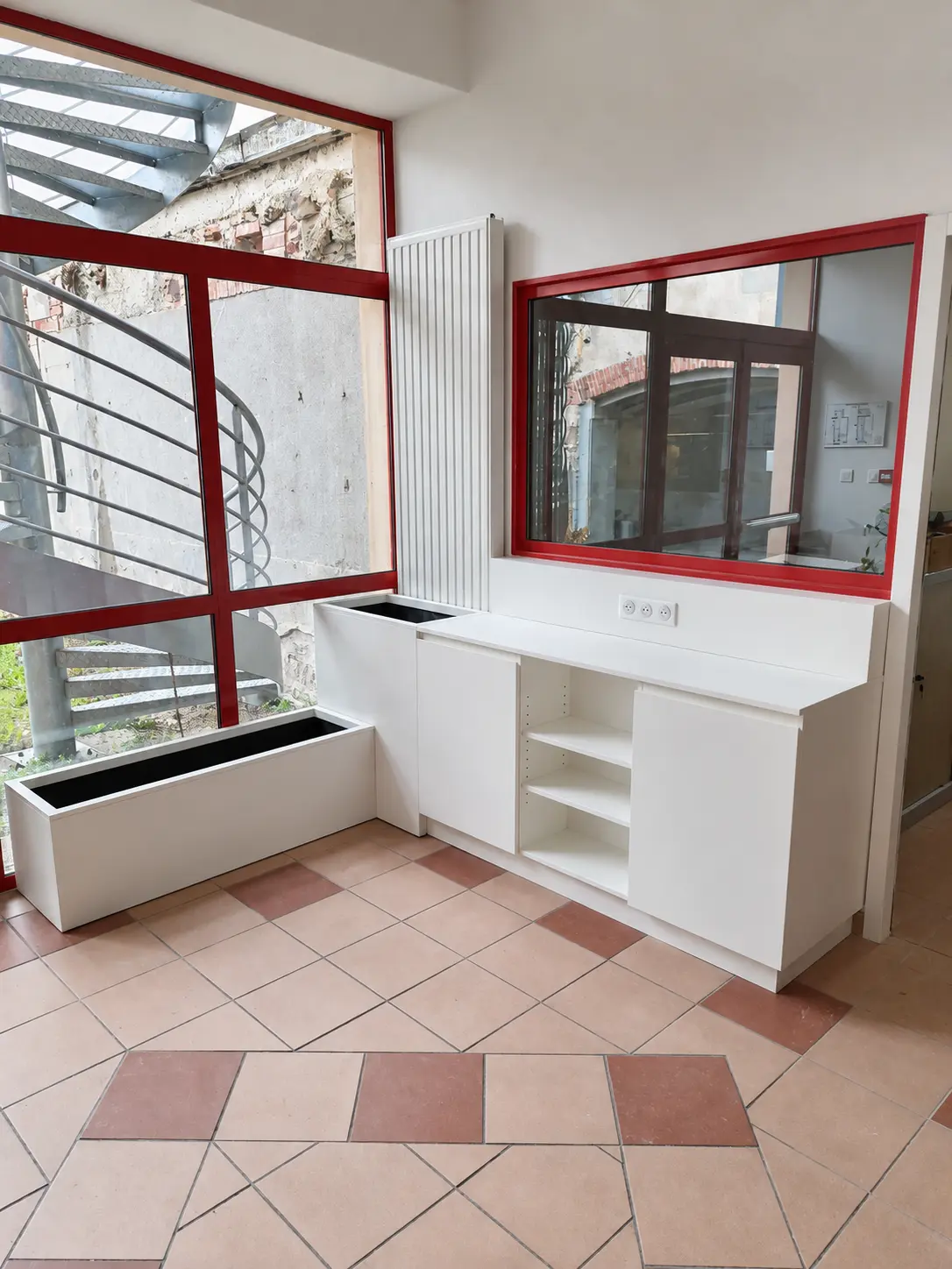 Meuble de rangement blanc et bacs à fleurs sur mesure dans un espace d’accueil